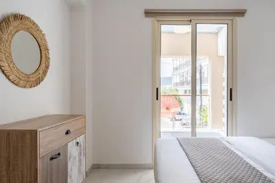 a bedroom with a bed and a mirror and a window at Infinity - One-Bedroom Apt W Terrace in Larnaca in Larnaka