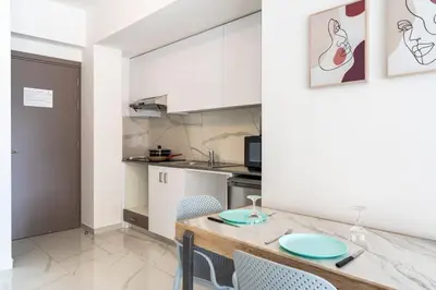 a kitchen with a table and chairs in a room at Sunny Side Studio W Terrace in Larnaca in Larnaka