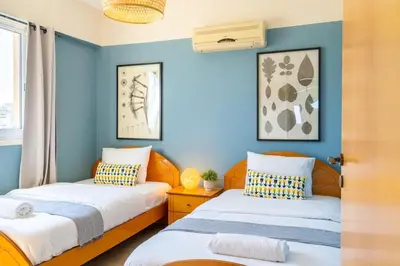 two beds in a room with blue walls at Bayview 2-BR Apartment W Terrace in Larnaca in Larnaka