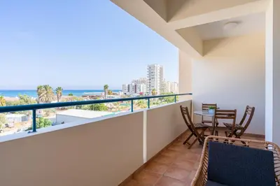 a balcony with a table and chairs and a view of the ocean at Bayview 2-BR Apartment W Terrace in Larnaca in Larnaka