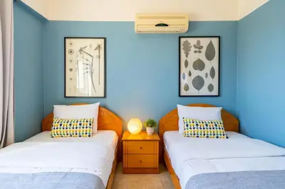 two beds in a room with blue walls at Bayview 2-BR Apartment W Terrace in Larnaca in Larnaka