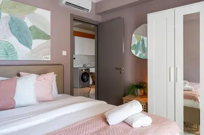 a bedroom with a bed with pink and white pillows at Sundrop - 1-Bedroom Apt W Terrace in Larnaca in Larnaka