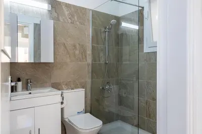 a bathroom with a shower and a toilet and a sink at Vibe - 1 Bedroom Apartment W Balcony in Larnaca in Larnaka