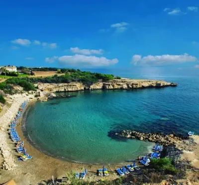 a beach with umbrellas and chairs in the water at Apartment Sun 'n Joy in Paralimni