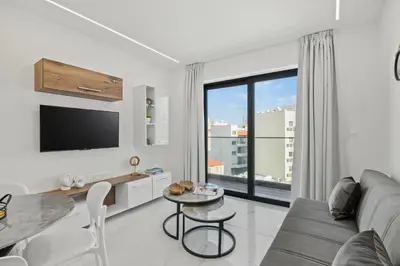 a living room with a couch and a table at Maestro City Apartments in Larnaka