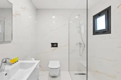 a bathroom with a shower and a toilet and a sink at Maestro City Apartments in Larnaka