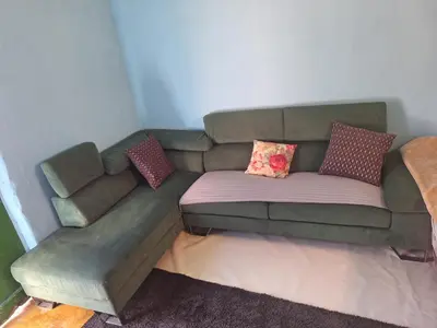 a green couch with pillows on it in a room at Room with entrance from yard near to Larnaca in Livadhia
