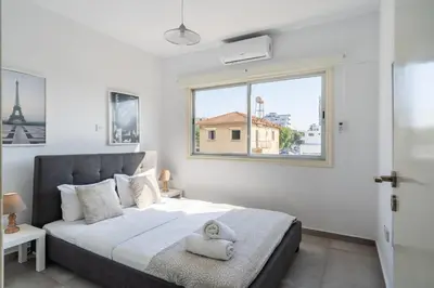 a bedroom with a large bed with a window at Liric - 3 Bedroom Apt W Balcony in Larnaca in Larnaka