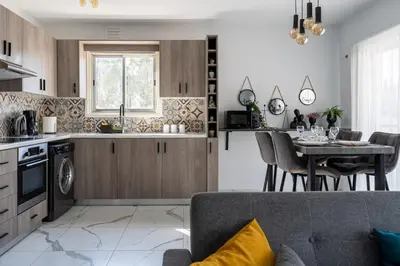 a kitchen and living room with a table and chairs at Liric - 3 Bedroom Apt W Balcony in Larnaca in Larnaka