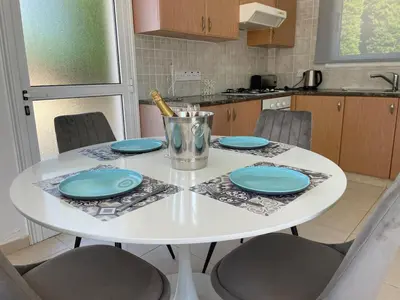a white table in a kitchen with blue plates at Villa Scarlett, Ayia Thekla in Ayia Napa