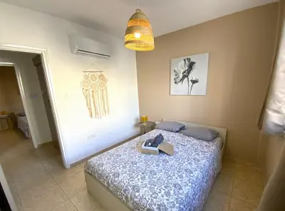 a bedroom with a bed with a book on it at Cozy 2BR Beach Apt, Perfect for Getaways in Larnaka