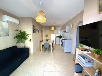 a living room and kitchen with a couch and a table at Cozy 2BR Beach Apt, Perfect for Getaways in Larnaka