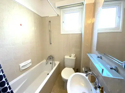 a bathroom with a tub and a toilet and a sink at Cozy 2BR Beach Apt, Perfect for Getaways in Larnaka