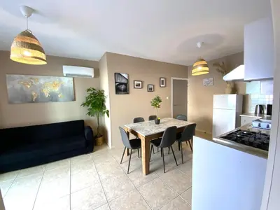 a kitchen and a dining room with a table and chairs at Cozy 2BR Beach Apt, Perfect for Getaways in Larnaka