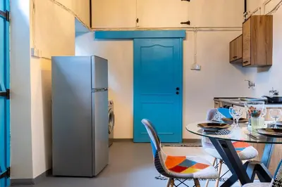 a kitchen with a refrigerator and a table with chairs at Blue Haven - 2-BR Artistic Escape in Larnaca in Larnaka