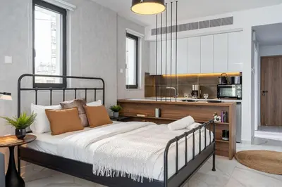 a bedroom with a large bed and a kitchen at Dusk - Harmonic Studio by Plus 49 in Mackenzie in Larnaka