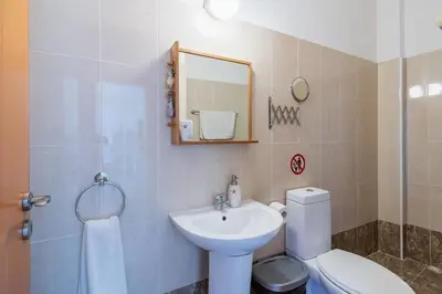 a bathroom with a sink and a toilet and a mirror at Glade - 1 Bedroom Apt W Balcony in Larnaca in Larnaka