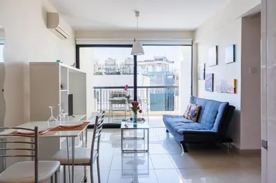 a living room with a blue couch and a table at Glade - 1 Bedroom Apt W Balcony in Larnaca in Larnaka