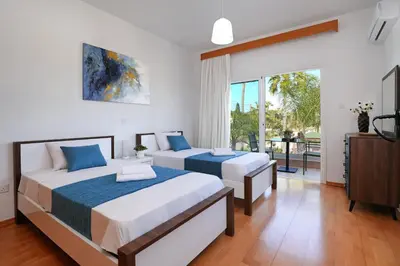 a bedroom with two beds and a balcony at Nissi Diamond Mansion in Ayia Napa