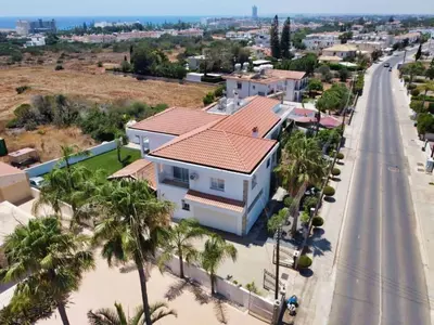 a house on the side of a road with palm trees at Nissi Diamond Mansion in Ayia Napa