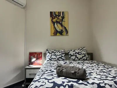 a bedroom with a bed and a painting on the wall at two-room apartment center in Limassol