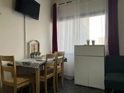 a kitchen with a table with chairs and a refrigerator at two-room apartment center in Limassol