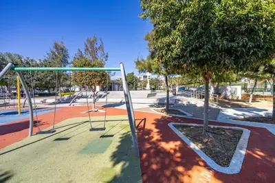 an empty park with a swing set and a tree at Olga Premium Apartments in Limassol