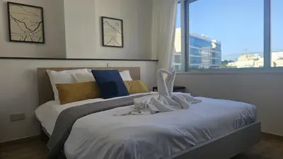 a bedroom with a bed with white sheets and a window at STAY City Center Gem in Nicosia