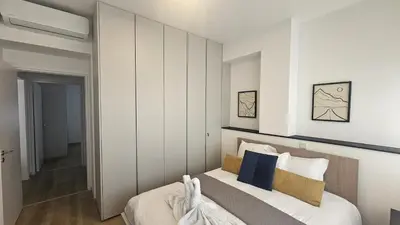 a bedroom with a bed with white walls and blue pillows at STAY City Center Gem in Nicosia