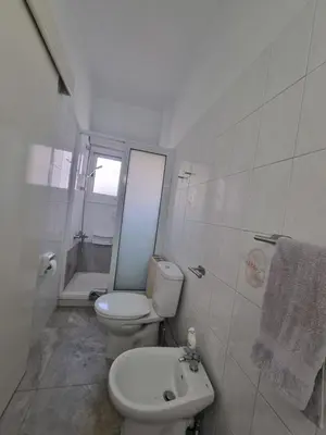 a white bathroom with a toilet and a sink at Jacobs home in Larnaka
