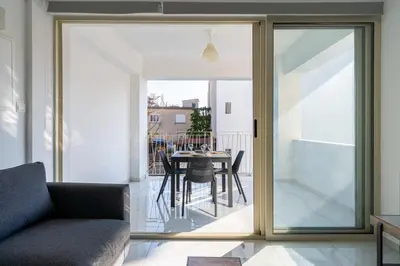 a living room with sliding glass doors and a table with chairs at Marble - Cozy Studio W Balcony in Larnaca in Larnaka
