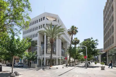 a large white building on a street with palm trees at Urban Condo 33 with Balcony - 2 Bdr in Nicosia
