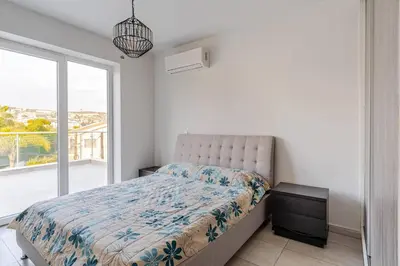 a bedroom with a bed and a large window at Penthouse Great View Hydromassage Penthouse hottub in Limassol