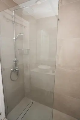 a shower with a glass door in a bathroom at WealthyStays 2BR Retreat , 5Min Walk to Beach in Protaras