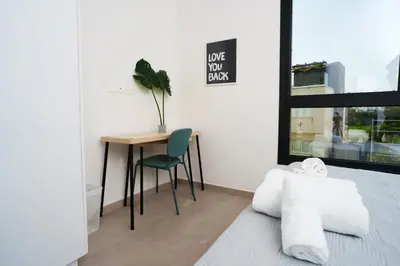 a bedroom with a desk and a bed and a table at WealthyStays 2BR Retreat , 5Min Walk to Beach in Protaras