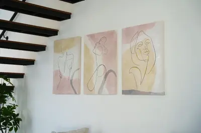 three paintings hanging on a wall in a room at WealthyStays 2BR Retreat , 5Min Walk to Beach in Protaras