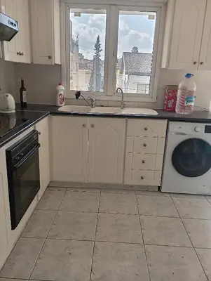 a kitchen with a sink and a washing machine at Eat well Sleep Well in Larnaka