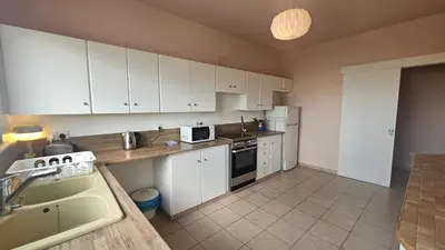 a kitchen with white cabinets and a sink and a microwave at STAY Velvet Apartment in Limassol
