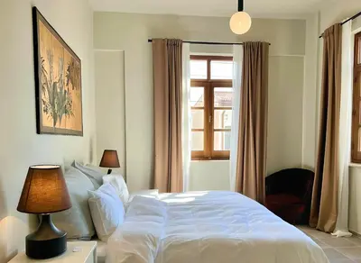 a bedroom with a white bed and a window at The Colonial in Larnaka