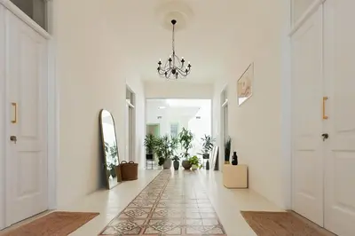 a hallway with white walls and a chandelier at Lito - Slow Living in Larnaka