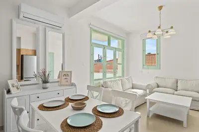 a white living room with a table and chairs at Lito - Slow Living in Larnaka