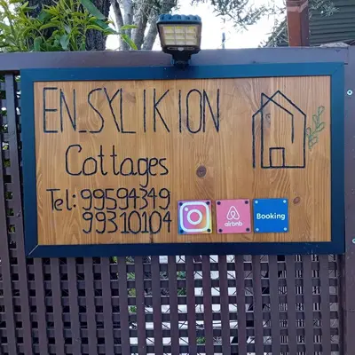 a sign on a fence that says autismlation cottages at En Sylikion cottage in Silikou