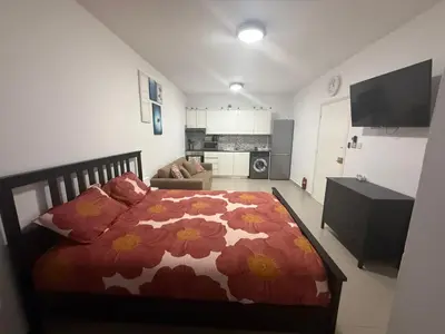 a bedroom with a bed with a flower comforter at Dene Hollow Ayia Napa 2 in Ayia Napa