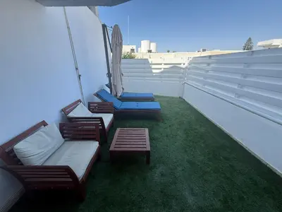 a balcony with chairs and a couch and a table at Dene Hollow Ayia Napa 2 in Ayia Napa
