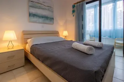 a bedroom with a bed with two towels on it at Large Veranda 2BR Walk to Beach in Paralimni
