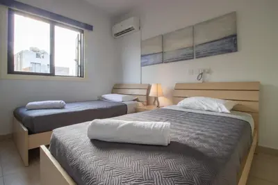 a bedroom with two beds and a window at Large Veranda 2BR Walk to Beach in Paralimni