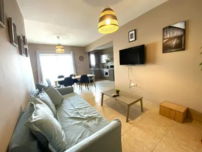 a living room with a couch and a table at 2Br Apt - 5mins walk to the Beach with Internet access in Larnaka