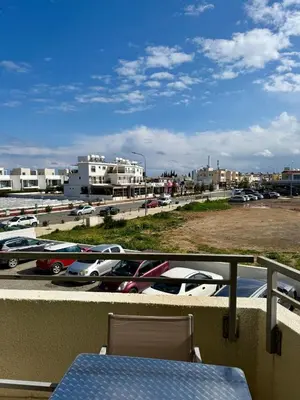 a balcony with a table and cars in a parking lot at Elena One Bedroom Budget Apt - License no 06991 in Paralimni
