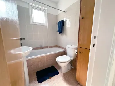 a bathroom with a toilet and a tub and a sink at Serenity Sunset Holiday Apt - Larnaca in Larnaka