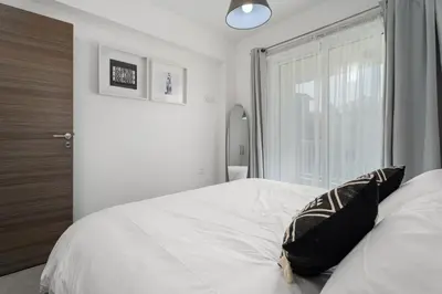 a bedroom with a white bed with a window at Cyprus Sun in Paralimni